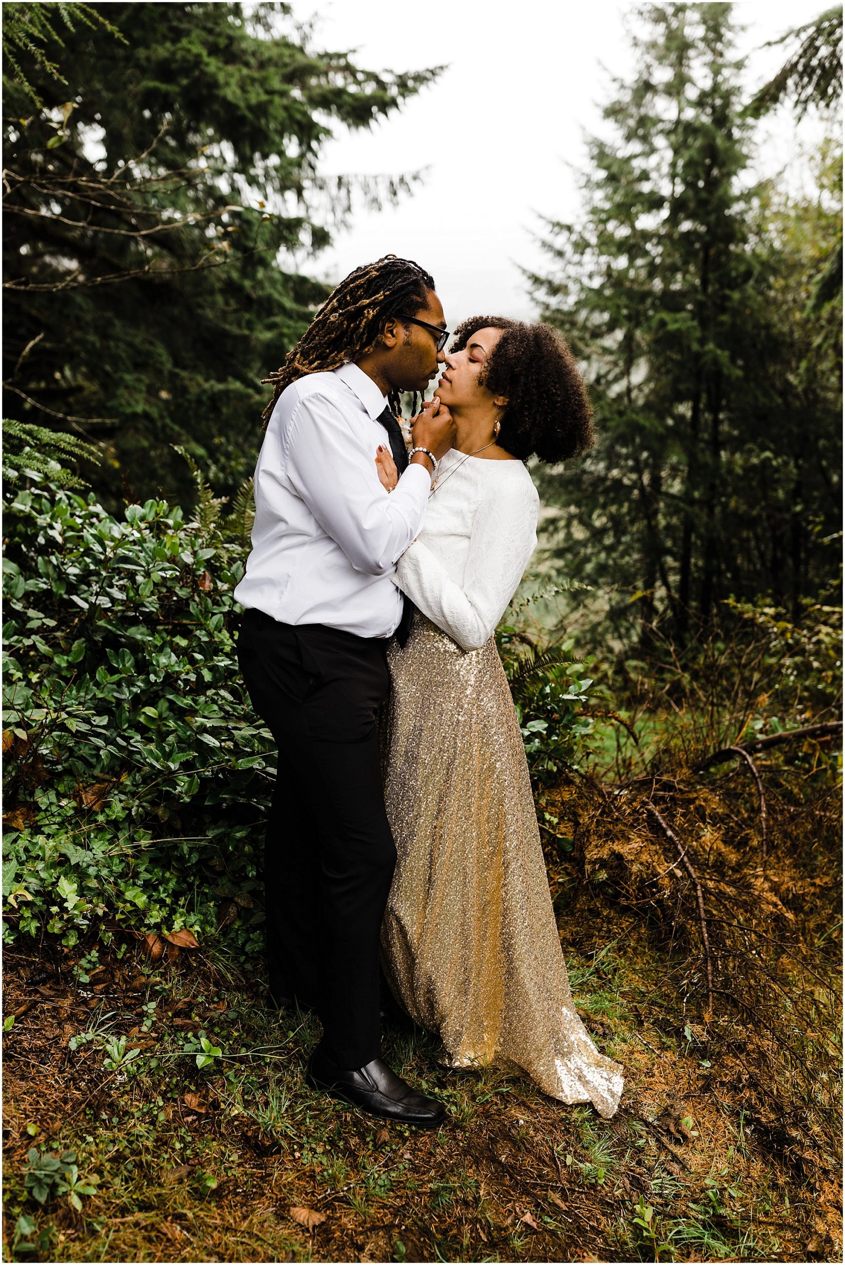 A gorgeous black man pulls his black bride's chin towards his for a romantic kiss on their Oregon Coast elopement day. | Erica Swantek Photography