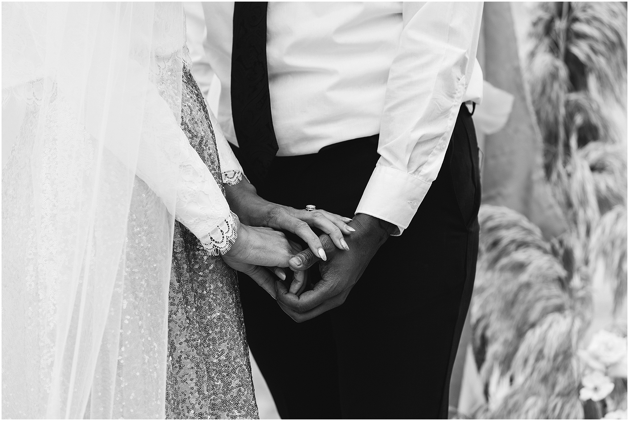 A beautiful black and white image of a BIPOC couple holding hands during their wedding vows on the beach of their Oregon Coast elopement. | Erica Swantek Photography
