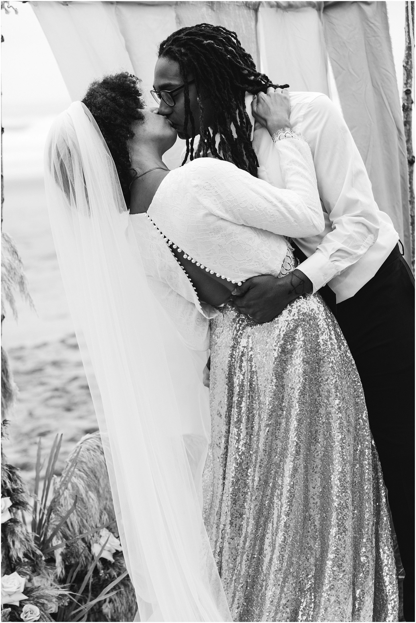 A stunning black and white image of a groom dipping his bride back for their first kiss during their Oregon Coast elopement. | Erica Swantek Photography