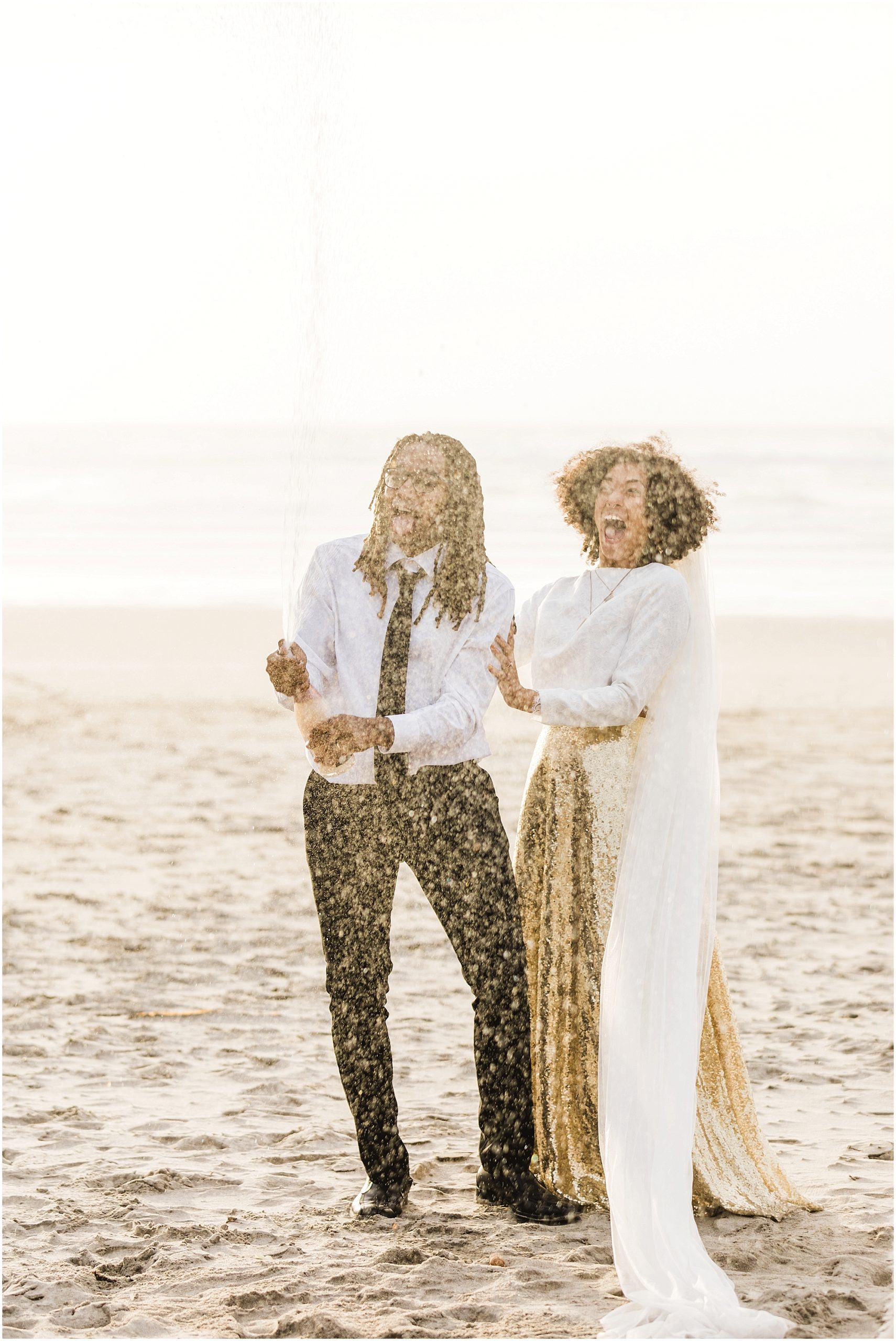 A black couple pops champagne on the beach to celebrate their wedding day during a beautiful Oregon Coast elopement in Neskowin. | Erica Swantek Photography