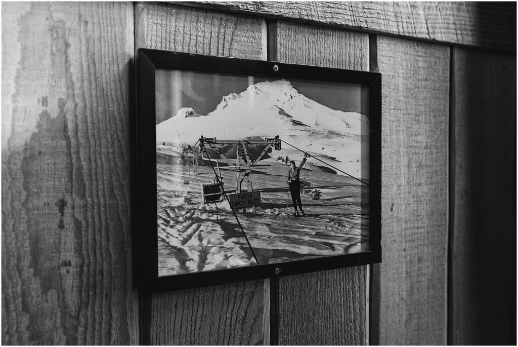 A black and white photo of a historic photo of a ski lift that sits on Mt. Hood hangs in the bunkhouse of the Silcox Hut. 