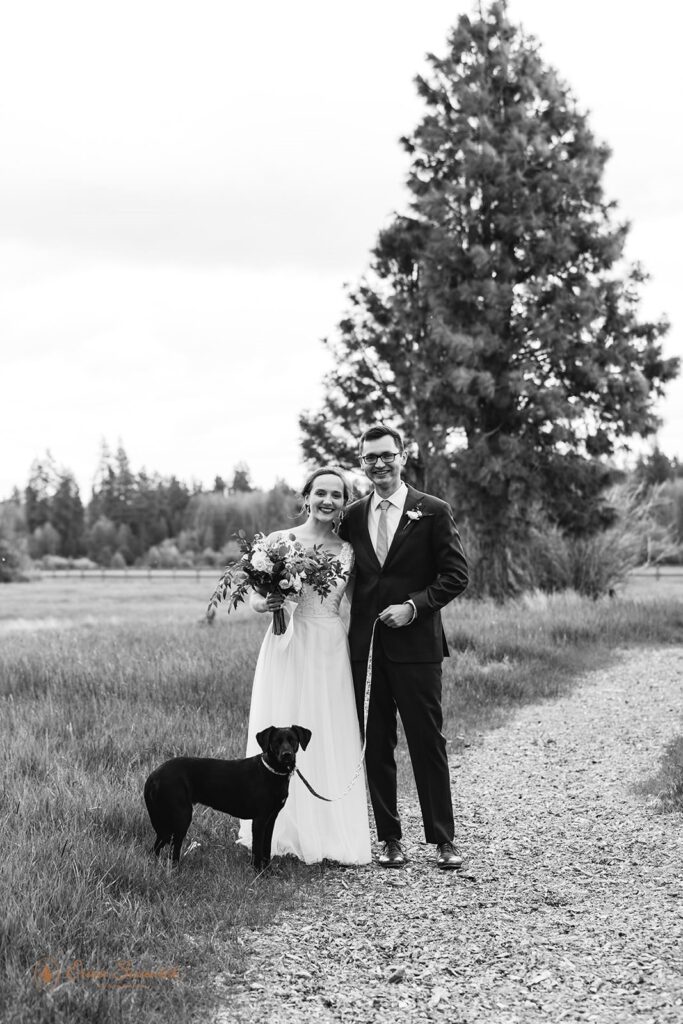 A couple with their dog poses for wedding portraits in Oregon.