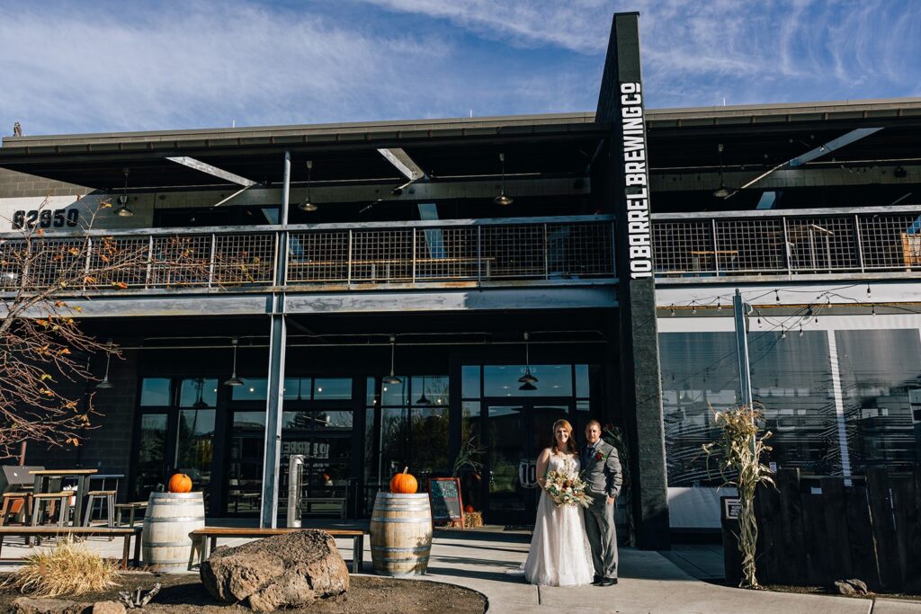 elopement couple posing by a brewery in oregon