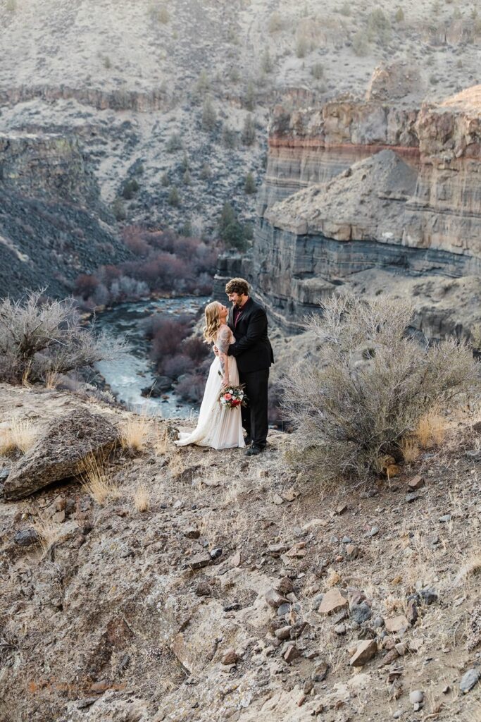 A couple goes in for a kiss overlooking a canyon in Central Oregon.