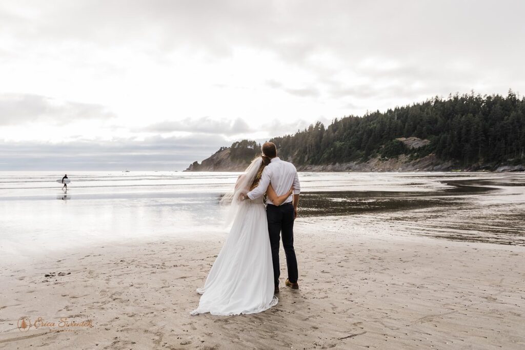 A couple embraces at a beach in Oregon during their adventure coastal elopement.