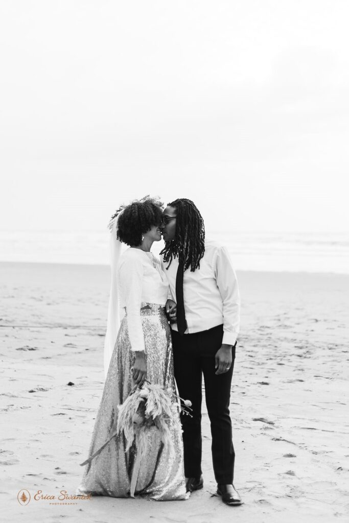 A couple kisses on a beach in Oregon during their pacific northwest elopement.
