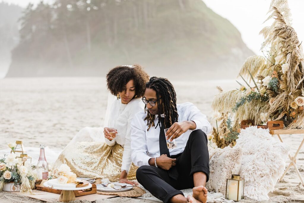 A couple enjoys a beach picnic during their Oregon beach elopement at Sunset.