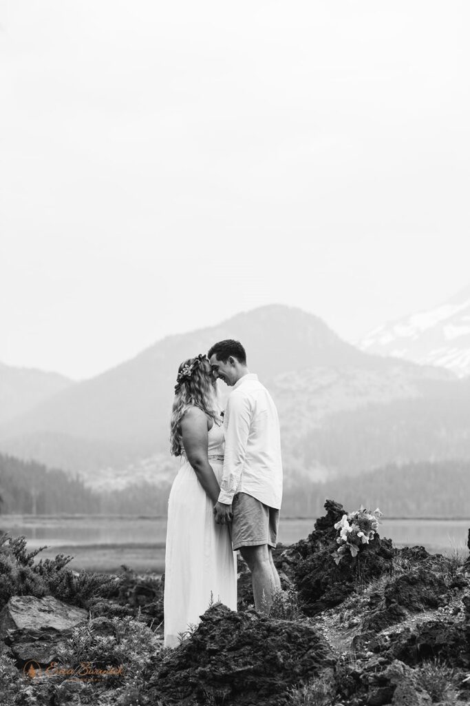 A couple stands near a lake reciting wedding vows.