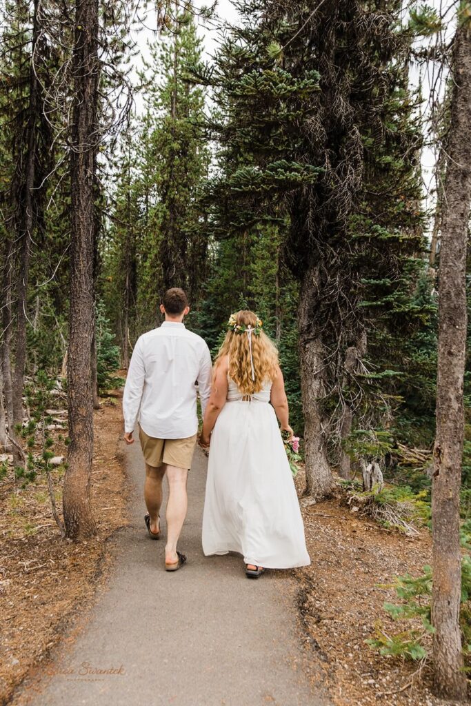 A couple holds hands and hikes during their Oregon elopement.