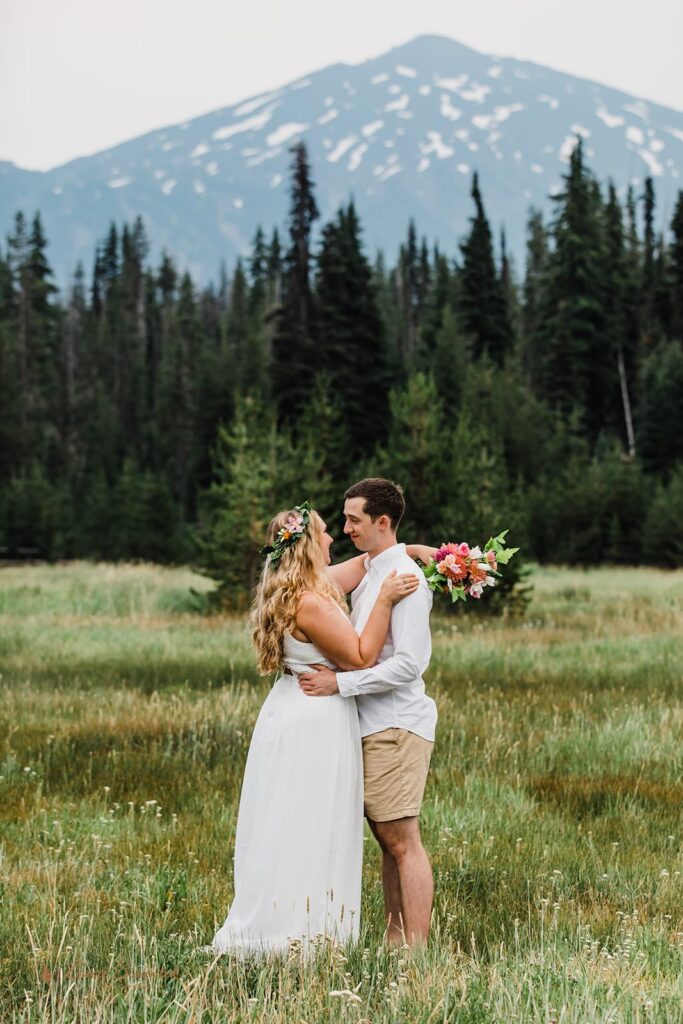 A couple embraces in an Oregon meadow.