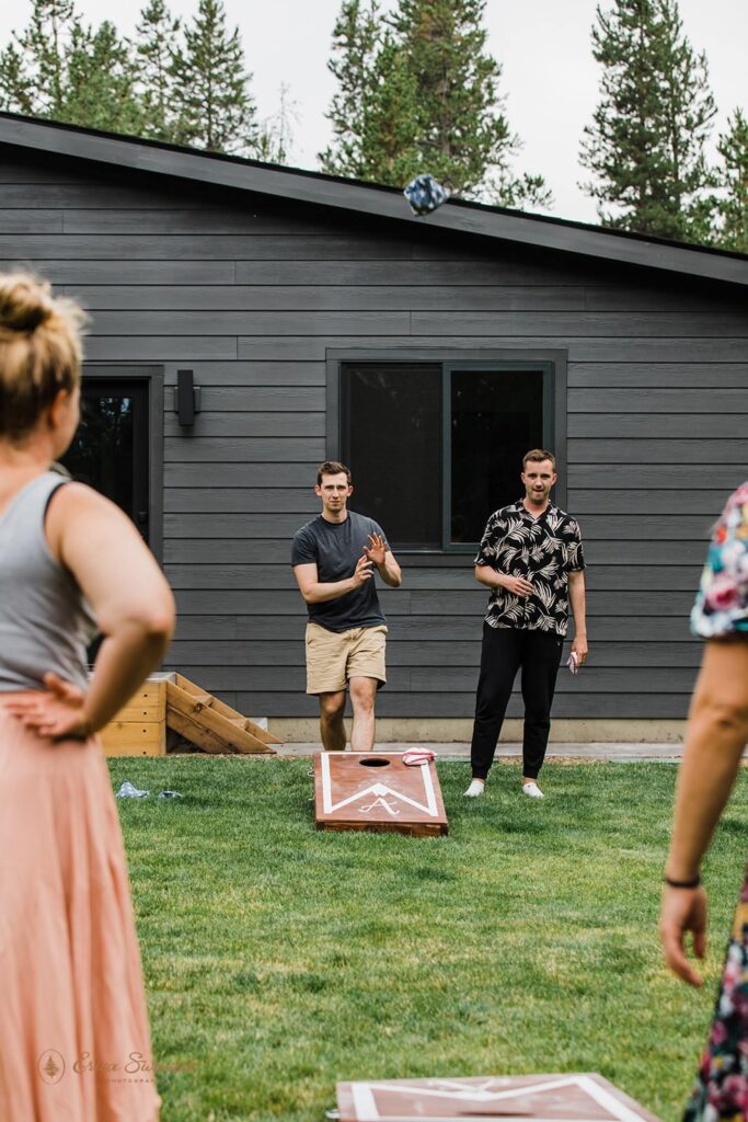 A man plays corn hole with his family.