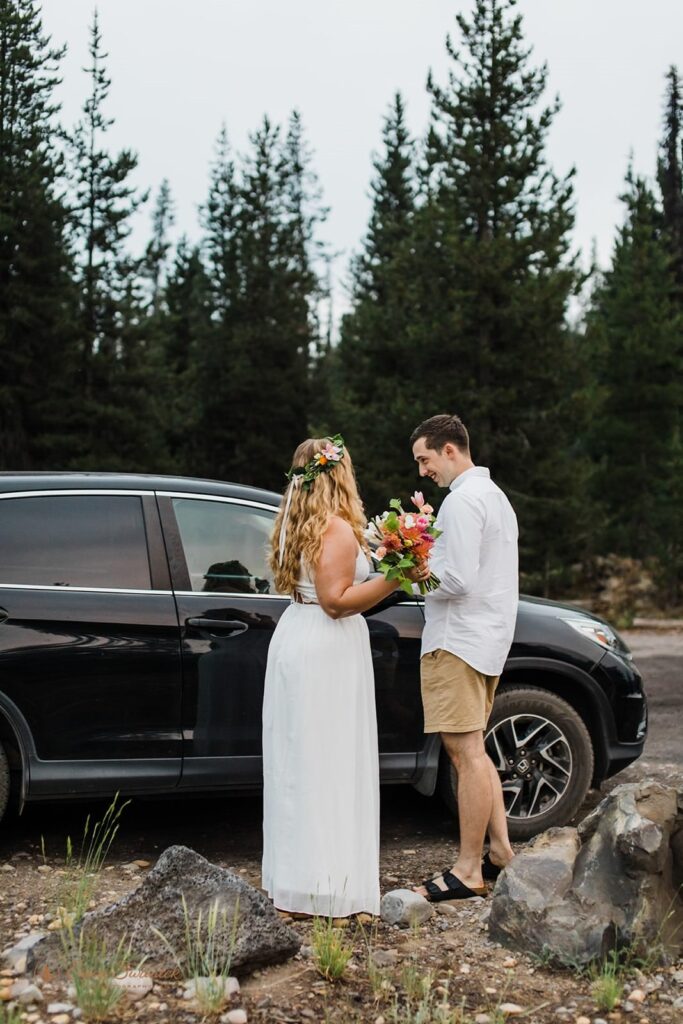 A couple gets ready for their Oregon elopement by their car.
