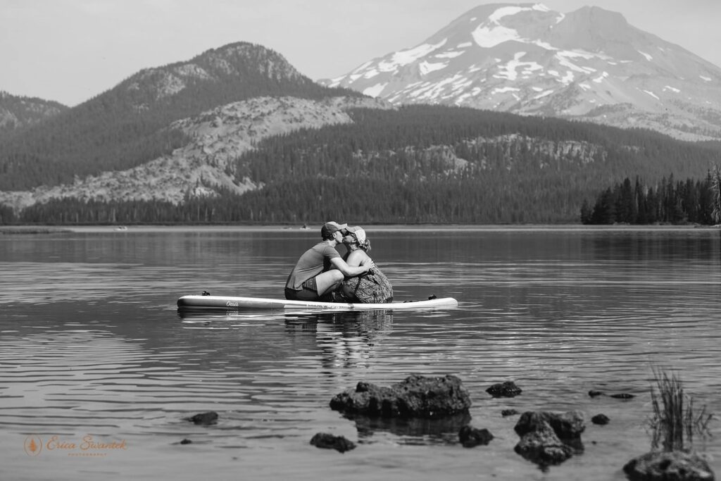 A couple kisses on paddle boards at Sparks Lake.