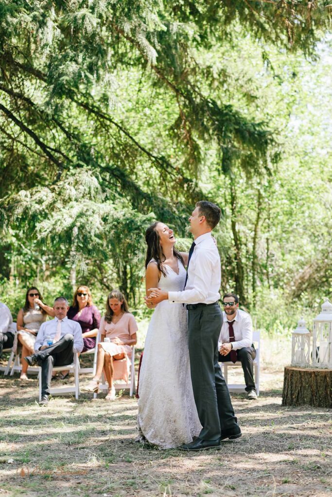A couple shares their first dance during an outdoor reception.