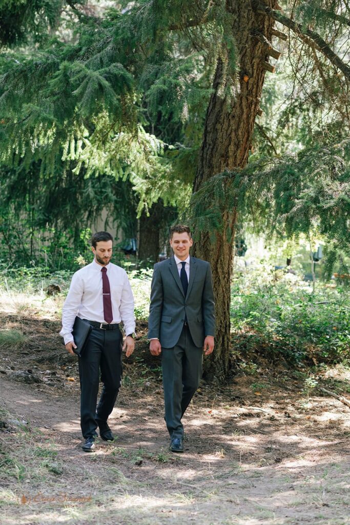 A groom and officiant walk to the alter for a forest elopement in Washington.