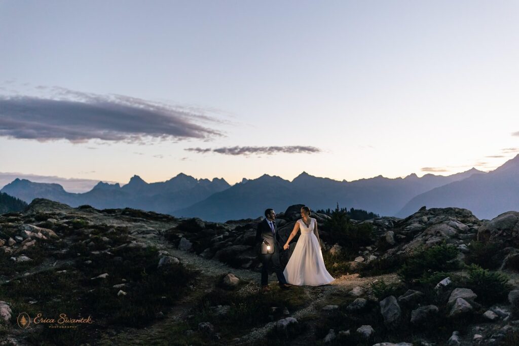 A couple holds lanterns while exploring North Cascades National Park during their Sunrise wedding. 