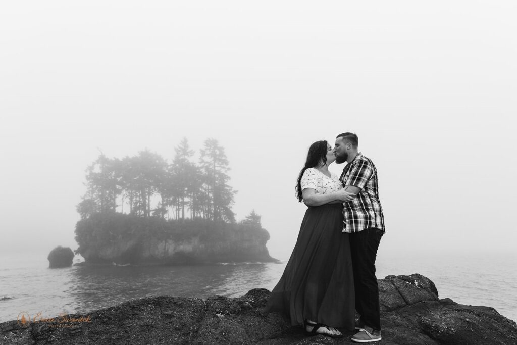 A couple kisses on a cliffside along the Washington coast. 