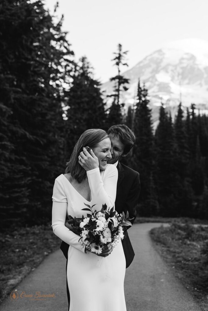 A man embraces his wife after their Mt. Rainier adventure elopement.