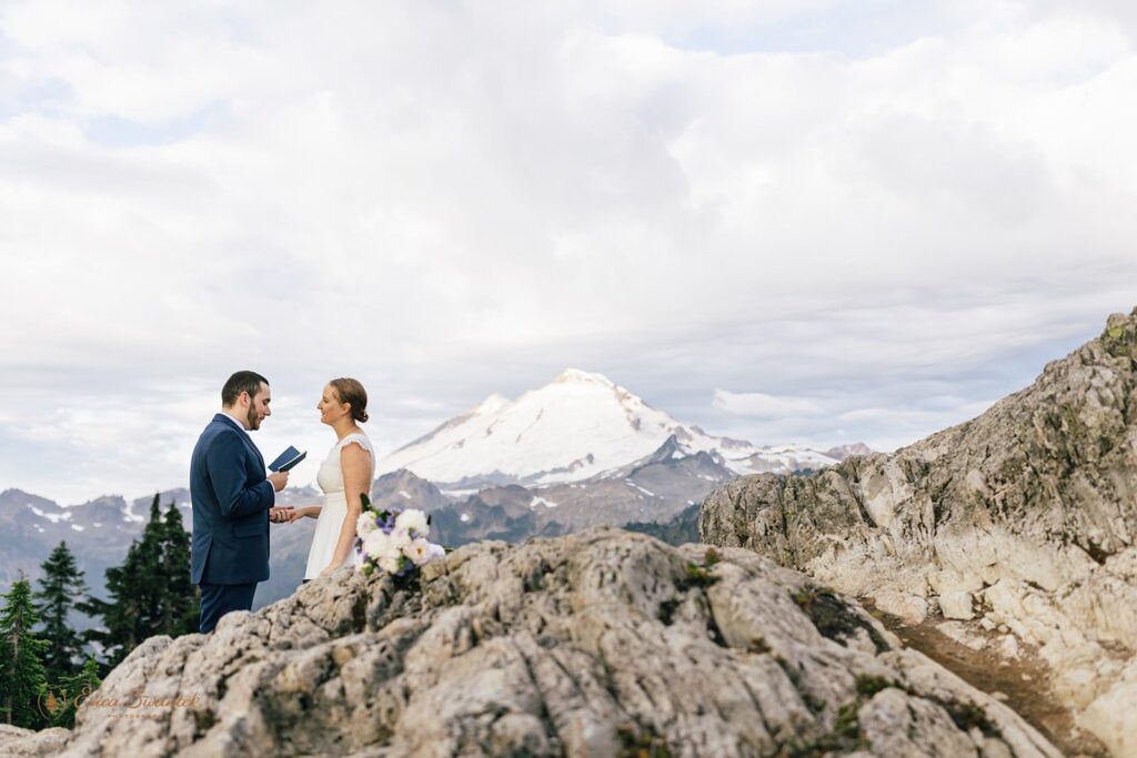 A snowy mountain is seen in the background of a Winter elopement in Washington State at Sunrise. 