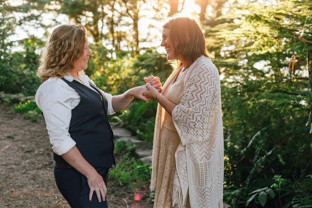 An Oregon elopement couple exchanges rings during an intimate vow ceremony at Sunset. 