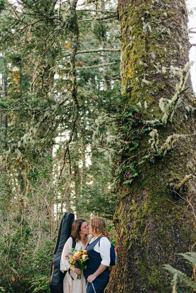 A couple kisses next to a Sitka Spruce in an Oregon temperate rainforest. 
