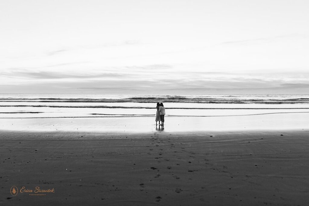 A couple embraces on Neptune Beach in Oregon at Sunset. 
