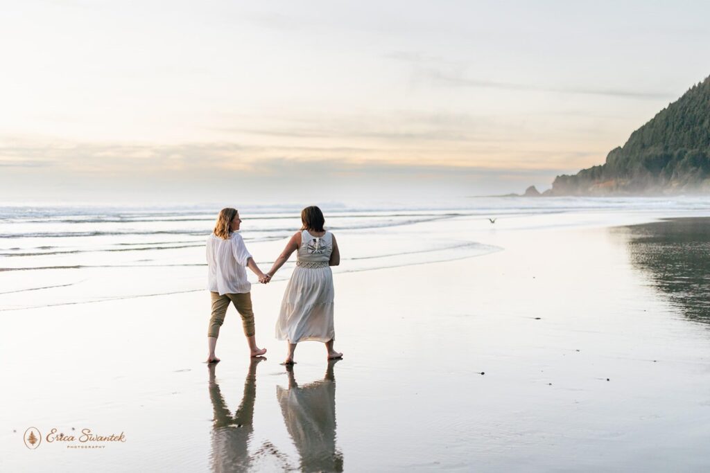 A couple holds hands during a Sunset elopement at Neptune Beach in Oregon.