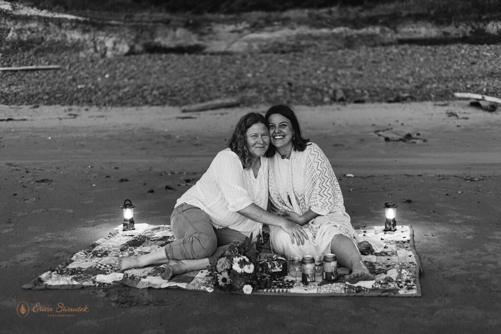  A couple cuddles on a picnic blanket after celebrating their coastal elopement in Oregon. 