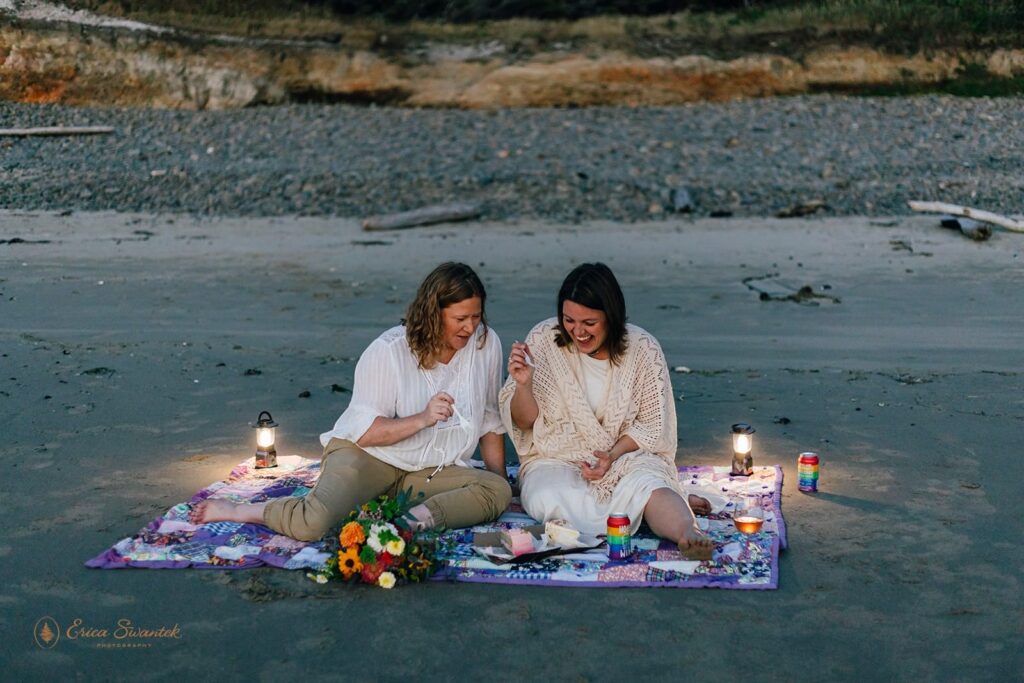 A newlywed couple shares a wedding cake on a picnic blanket on Neptune Beach.