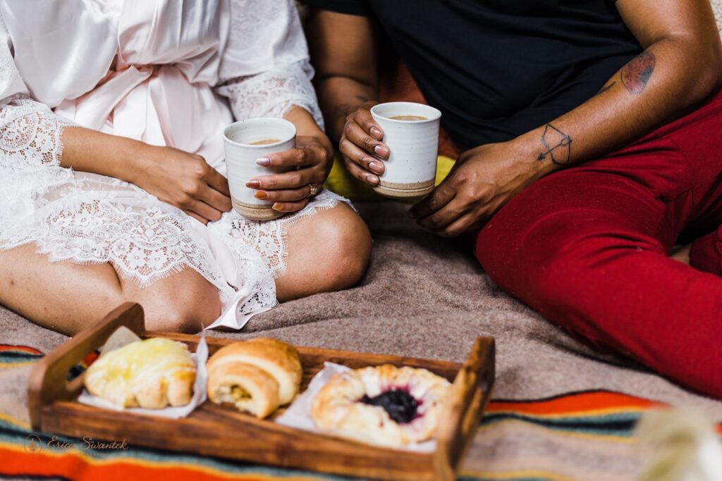 A couple shares pastries in bed, along with a cup of coffee at their Oregon Airbnb.