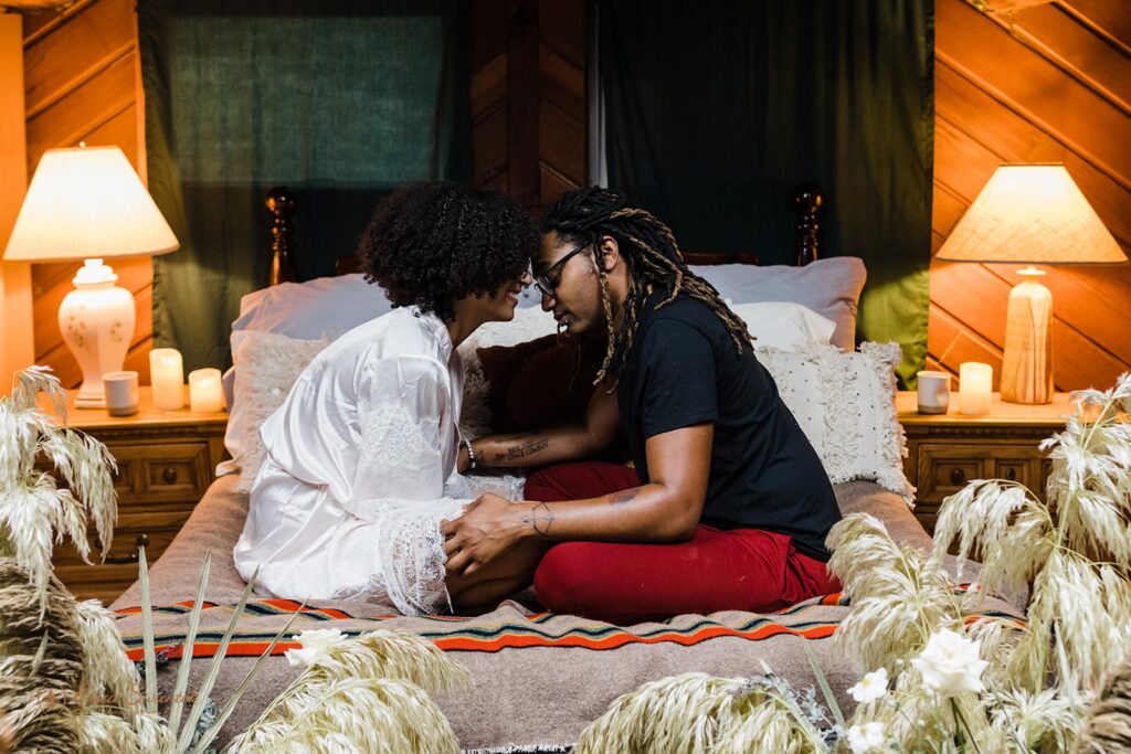 A couple embraces on a cozy Oregon Airbnb bed. 