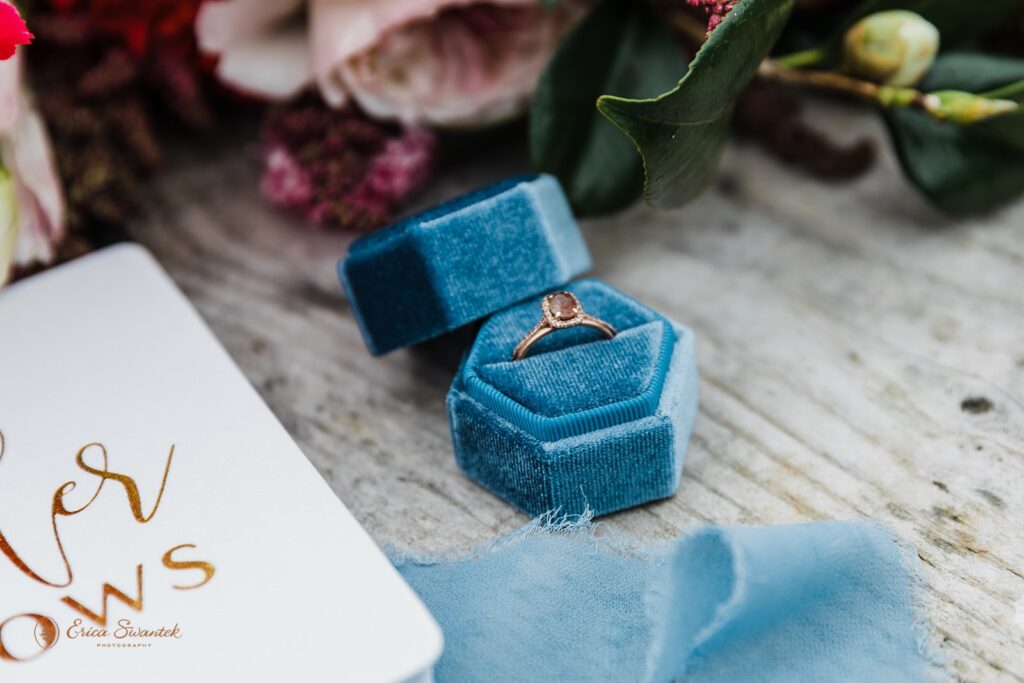 A blue velvet ring box holds a vintage ring. 
