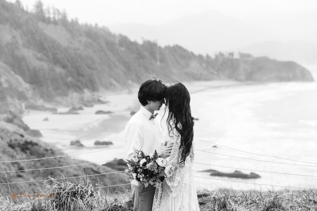 A couple embraces during their beach elopement on a misty Oregon day along the pacific coast. 