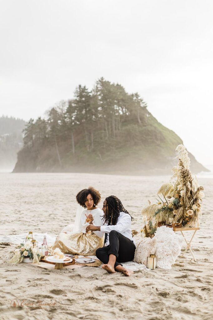 A couple shares a beach picnic in celebration of their Neskowin Beach elopement.