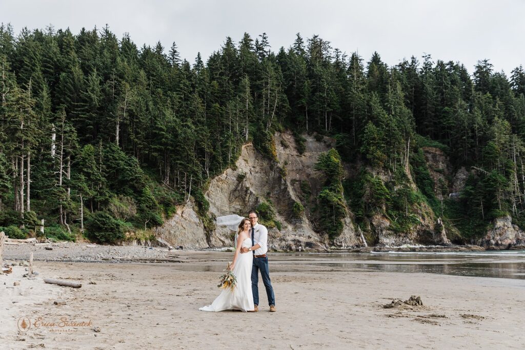 An elopement couple embraces on a rocky Oregon beach near Elks Flats Trail. 