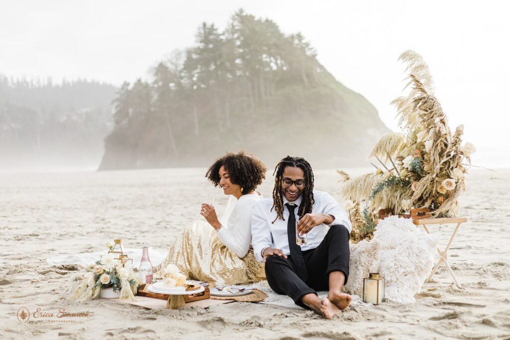 A couple enjoys a boho picnic near Proposal Rock during their beach elopement along the Oregon Coast.