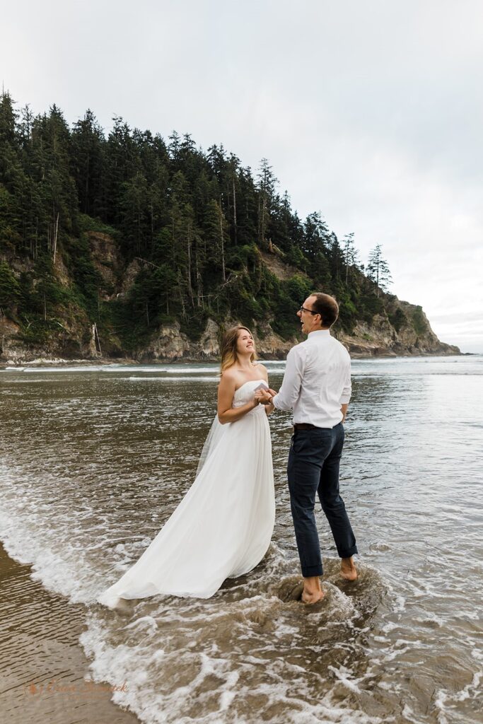 A couple stands in the surf during their romantic vow ceremony on the Oregon Coast at Short Sand Beach.