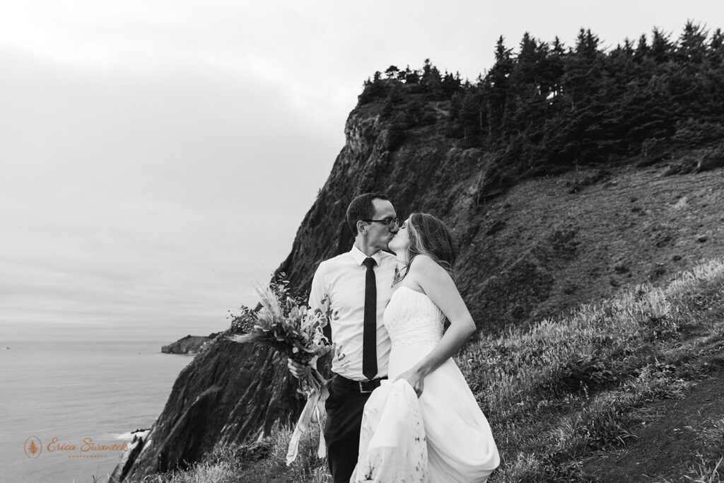 A couple shares a kiss on Elk Flats Trail during their hiking elopement along the Oregon Coast. 