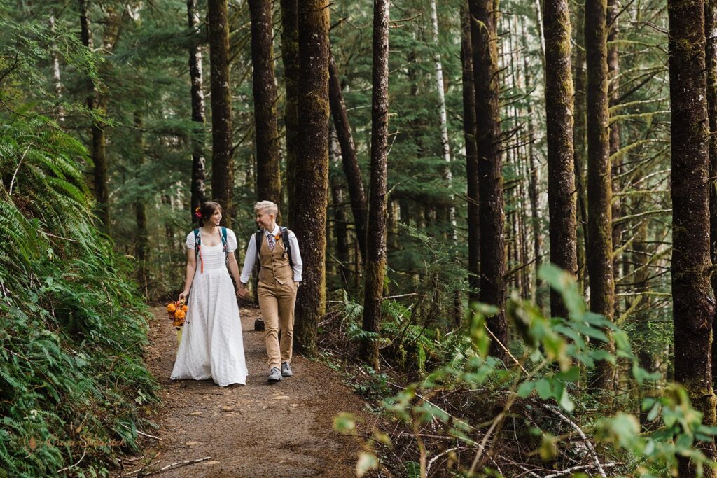 A couple holds hands while walking in Otis, Oregon, during their Oregon Coast Elopement. 