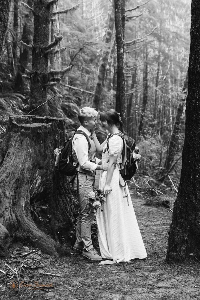 A hiking elopement couple stops to embrace during their intimate celebration in the Pacific Northwest.