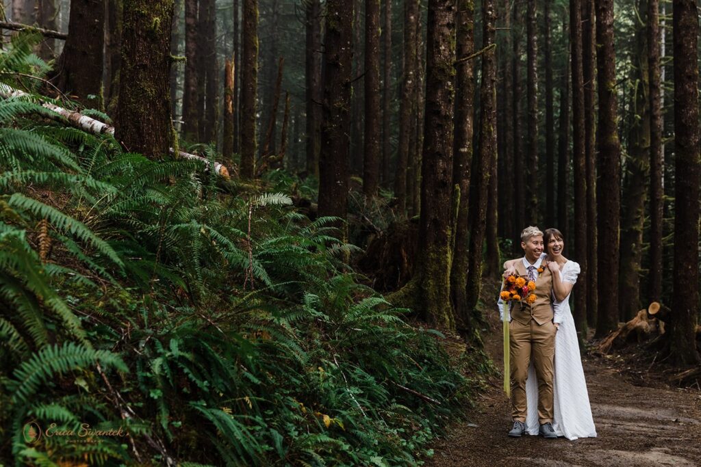 A newly eloped couple poses for portraits amongst towering pine trees in an Oregon forest.
