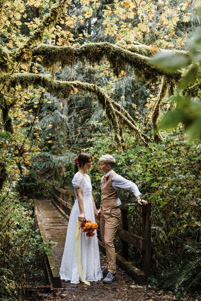 A newly married couple stands along a hiking path during their National Forest elopement in Oregon.