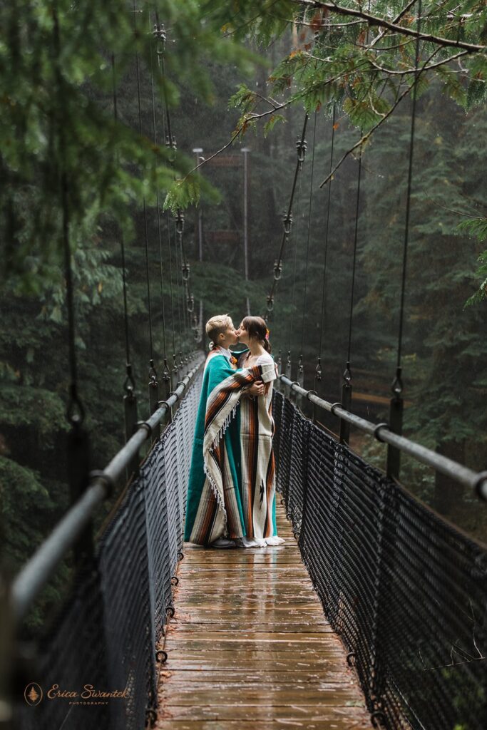 A couple kisses during their adventure elopement while standing on a suspension bridge along Drift Creek Falls Trail.