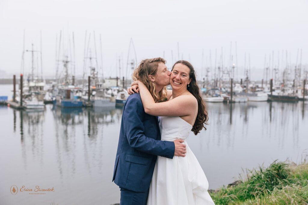 sweet elopement couple posing at a cute harbor during their oregon coast elopement in newport