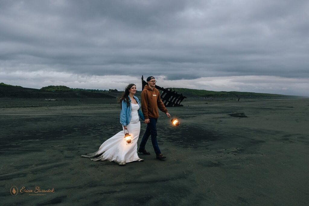 bride and groom walking with lanterns during their oregon coast elopement