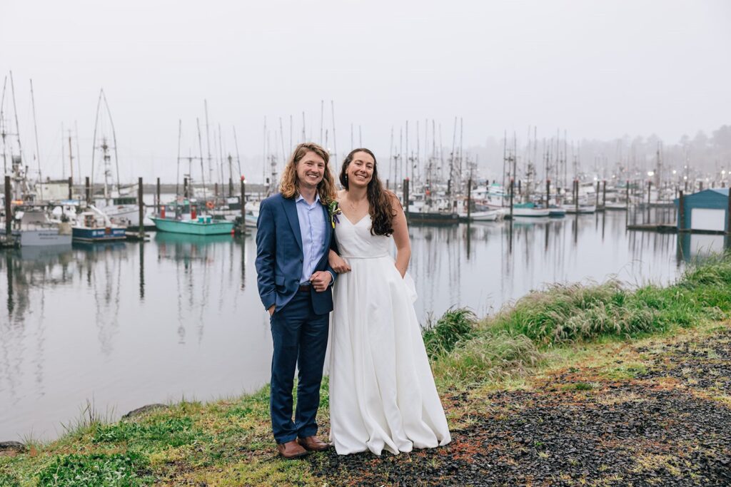 sweet elopement couple posing at a cute harbor during their oregon coast elopement in newport