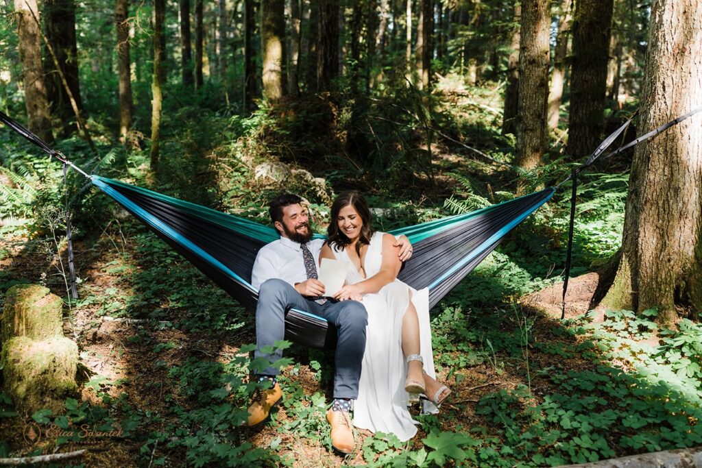 A Mt. Rainier elopement couple share love notes in a hammock. 