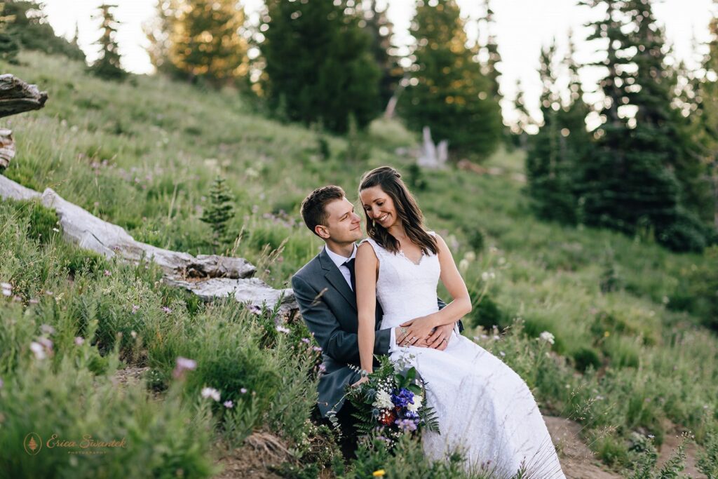 A couple embraces in a Mt. Rainier wildflower meadow during their outdoor Summer elopement in Washington. 