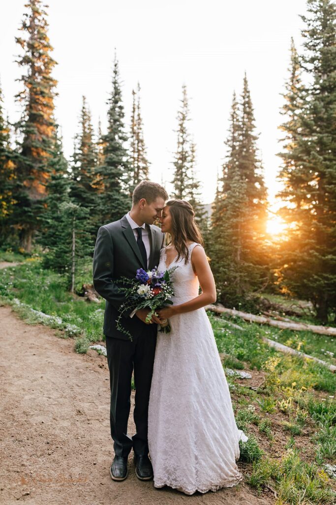 A bride and groom rests their foreheads on one another at Sunrise on a trail during their Mt. Rainier hiking elopement.