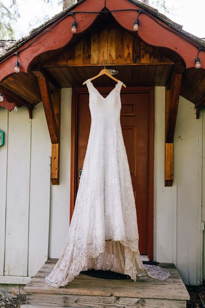 A wedding dress hangs from a wooden frame of a cabin at Whistlin' Jack's in Washington. 